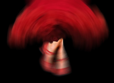 a photo of a flamenco dancers red dress and red shoes stylized to show movement